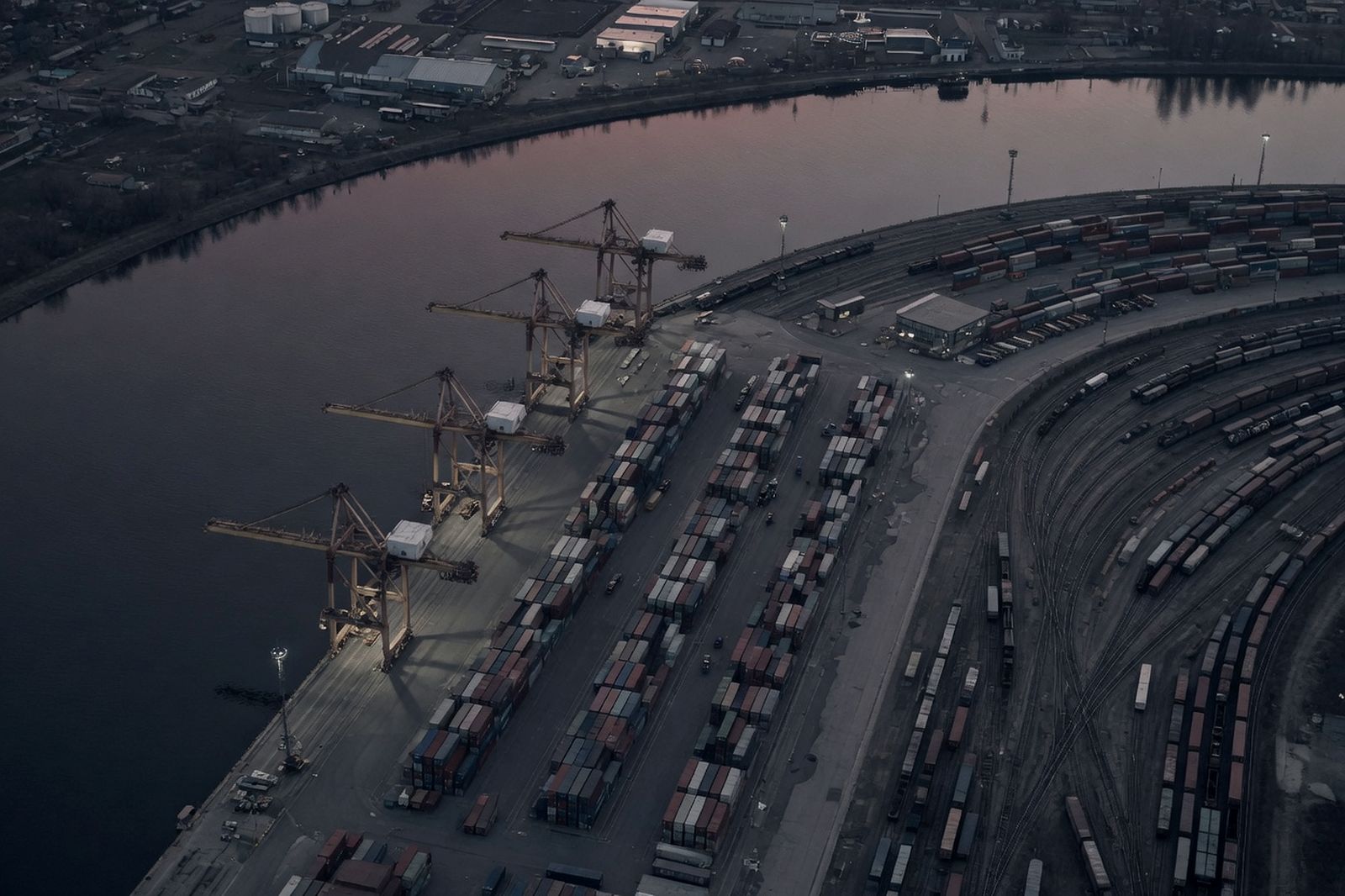 A regional port and rail yard from above at dusk